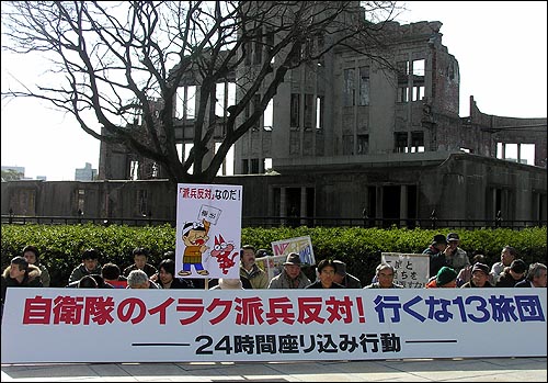 지난 28일 일본 히로시마 원폭공원 원폭돔(겐바쿠돔) 앞에서 한 단체가 "이라크 파병 반대"를 주장하며 침묵시위를 벌이고 있다. 